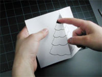 A person is explaining that how to make a christmas tree pop-up card.