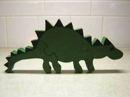 A green puzzle dinosaur toy sits on a table.