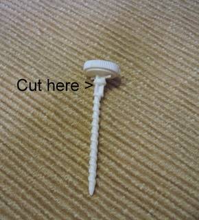 A plastic screw with "cut here" written near its top.