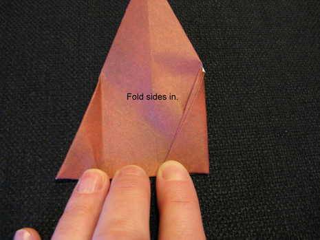 Man is showing paper folding to prepare paper Santa.