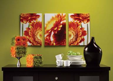 A black shelf has colorful decorations, plates, mugs and there is a picture on the wall.