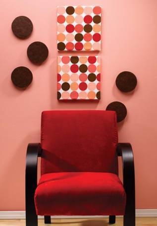 A red chair sits in front of a wall with colorful artwork.