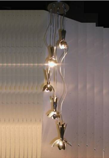A sculptural light fixture that hangs from the ceiling and made from spoons.