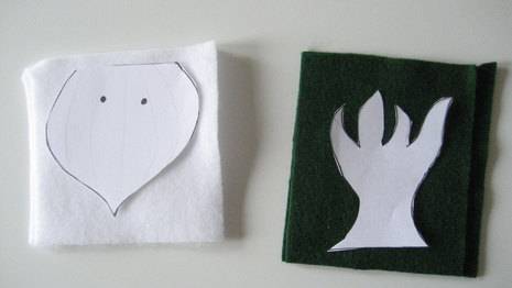 A piece of paper is cut into a tree and drop shapes placed in a black and white color cloths.