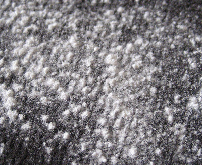 White powder dusted over a dark grey fabric.