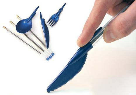 A hand holding a blue pen with a plastic knife tip and a spoon, fork and knife tip and three pens laying on a white surface.