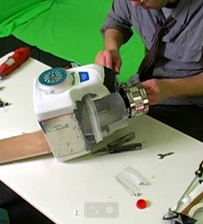 A man works on making a realistic looking chainsaw arm.