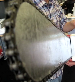 " A man holding  a chainsaw arm"