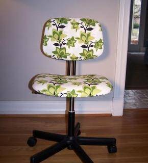 A swiveling computer chair without arms in a floral pattern.