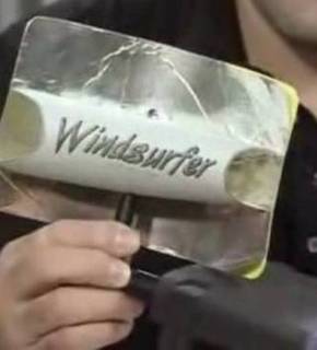 A person is showing a WiFi extender with windsurfer text on it.