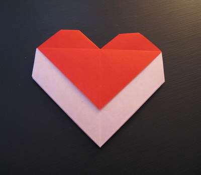 "A hand made envelope is done in hearten shape , using red and white papper "