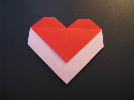 "A hand made envelope is done in hearten shape , using red and white papper "