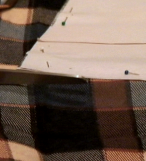 A cloth piece of fabric being tacked to a white board.