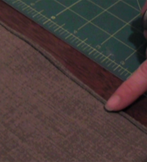 Person using their finger to hold down edge of fabric they folded over.