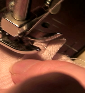 A man is stitching with a sewing machine.