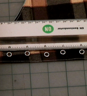 A white ruler that is being used to measure a piece of fabric.