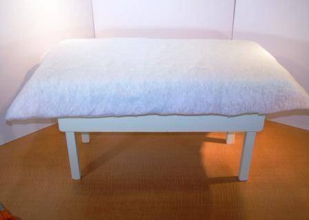 White color foam fabric is covered to a table.