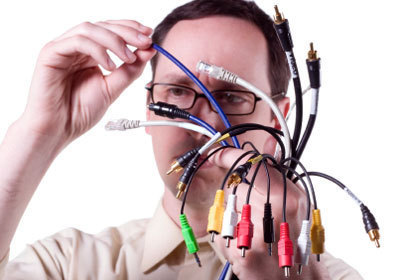 A person is holding a mess of wires in front of their face.