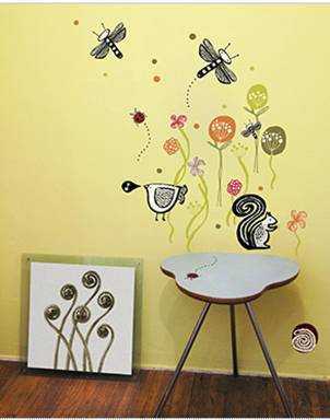 Wall print with bees, flowers and squirrel on yellow wall and three legged table and painting frame aside.