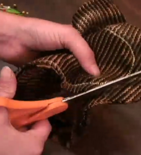 Person using scissors to cut into a sweater.