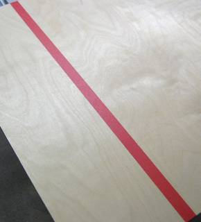 A red line is spread out over a wooden surface.