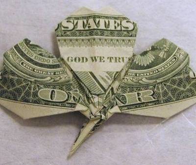 A dollar bill has been folded to look like a clover.