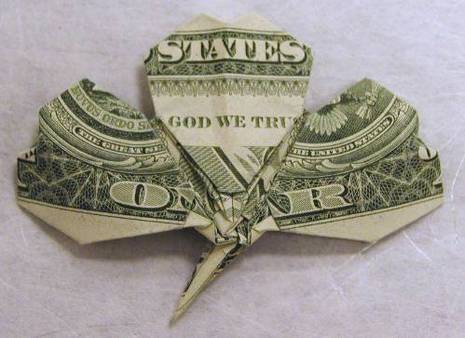 A dollar bill has been folded to look like a clover.