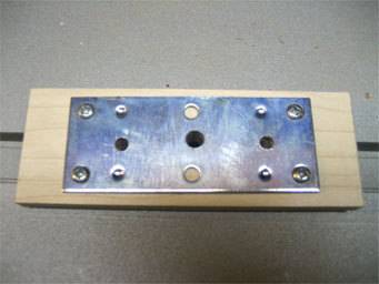 Screws are placing a metal plate into wood.