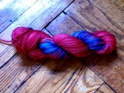 Red and blue hair is braided on a wooden floor.
