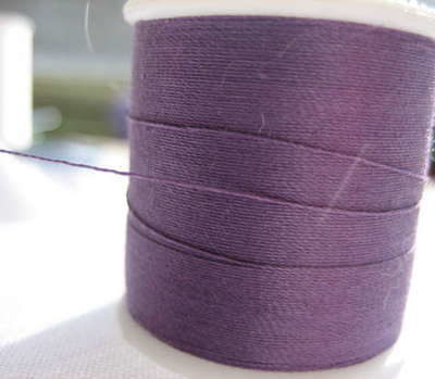 Purple string is wrapped around a spindle.