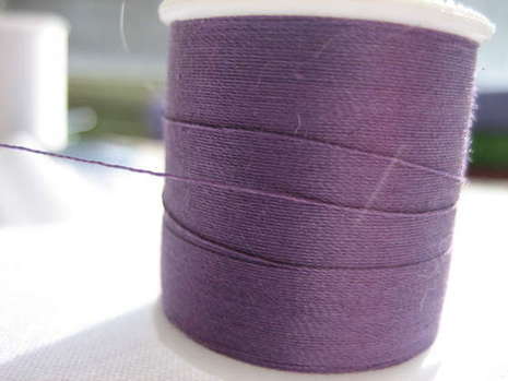 Purple string is wrapped around a spindle.