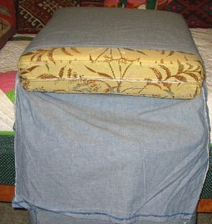 A cushion is inserted into a grey pillowcase.
