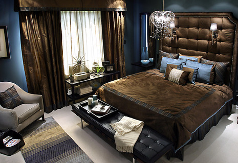 Chocolate color bedroom with bed, couch, chair, bed lights, and shandler.
