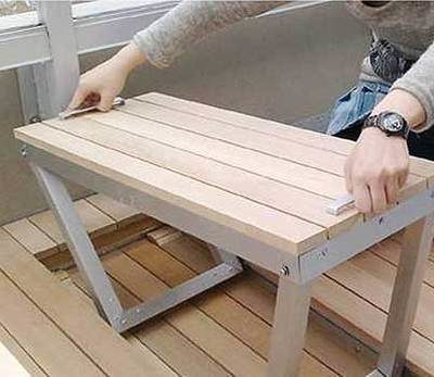 A small folding desk that pops out of a wooden deck.
