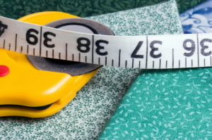 A tape measurer is spread out over some fabrics.