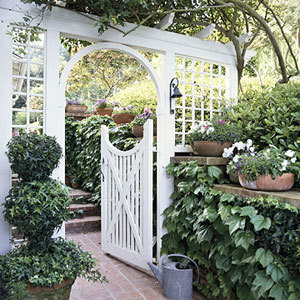 A white garden gate is open.