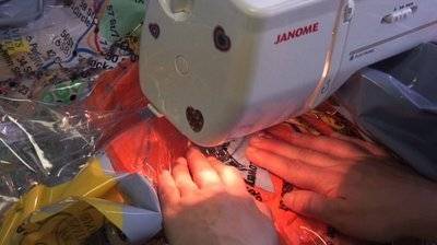A tailor stitching the clothes in sewing machine