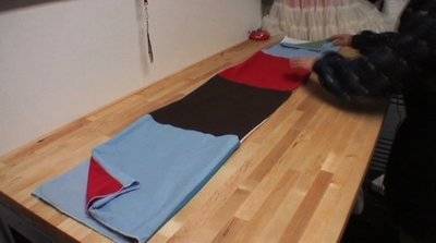 A person laying out multiple pieces of fabric.