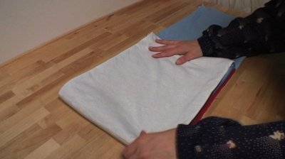 A person laying out white fabric