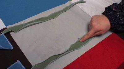 A person runs their finger down a green material.