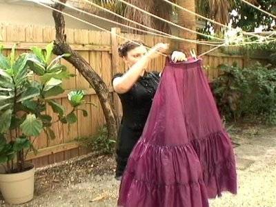 Woman drying sweeny todd vintage inspired dress on rope and putting clips to it.