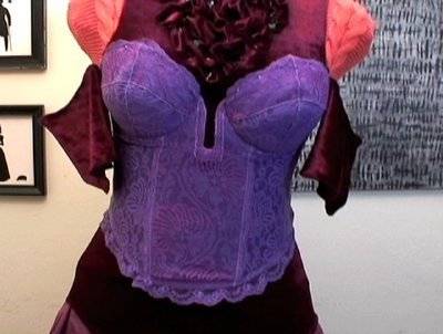 A purple corset, that is currently on a dummy.