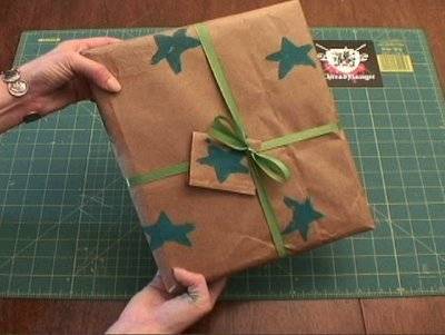 Man showing gift packet wrapped with star printed paper and tied with ribbon.