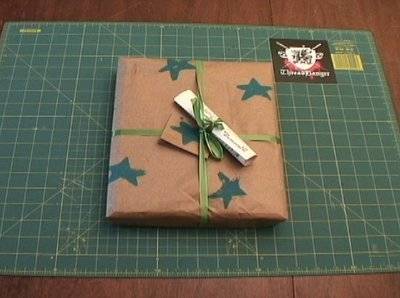 A wrapped brown present with a green bow on a table.