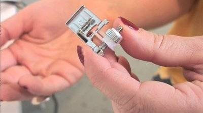A hand holding a tiny electrical component.