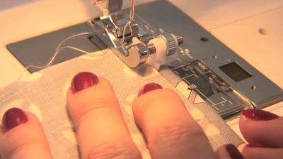 A woman stitching on her sewing machine.
