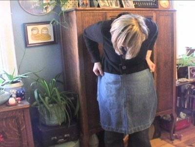 " A woman  checks and tries to match an Apron out of old jeans "