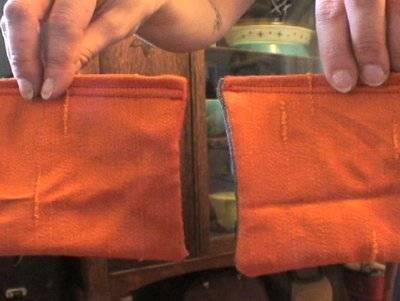 An orange woven piece of fabric makes up one side of a sewn object, and there are two of these.
