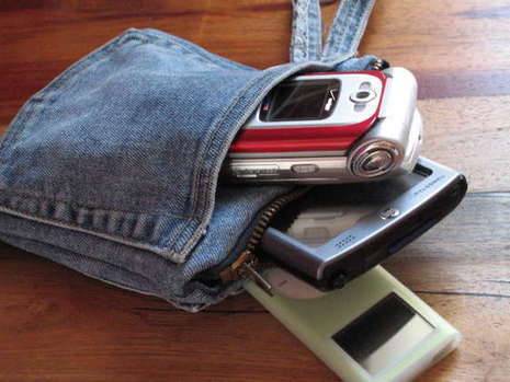 Three electronic devices sit in a denim pouch.
