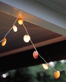 A string of clam lights hanging from a white beam.